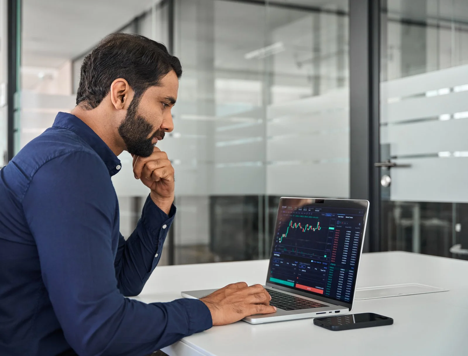Mann wertet Daten am Laptop im Büro aus