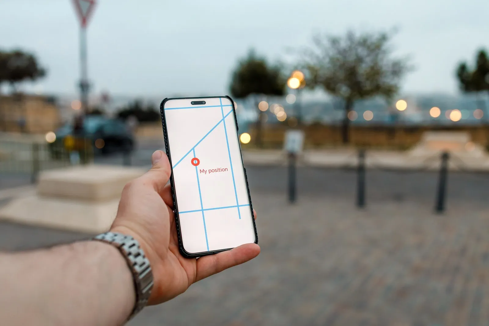 Hand hält ein Smartphone mit Kartenansicht und Standortmarkierung
