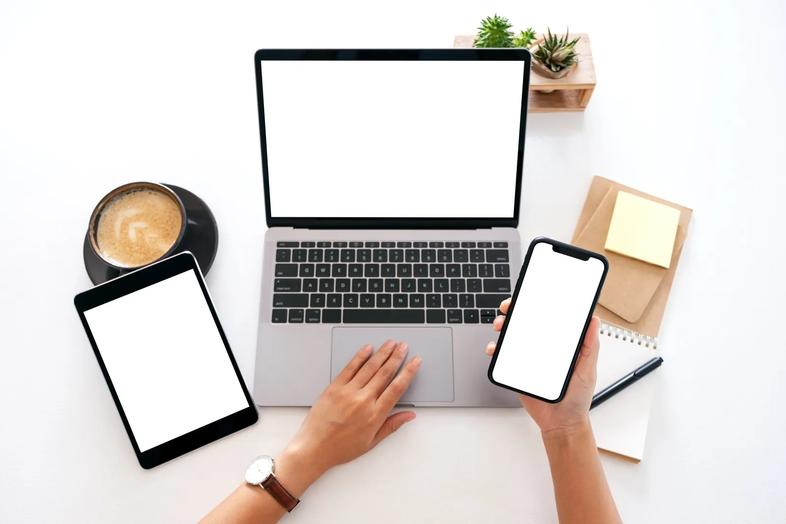 Laptop, Tablet und Smartphone auf einem hellen Schreibtisch