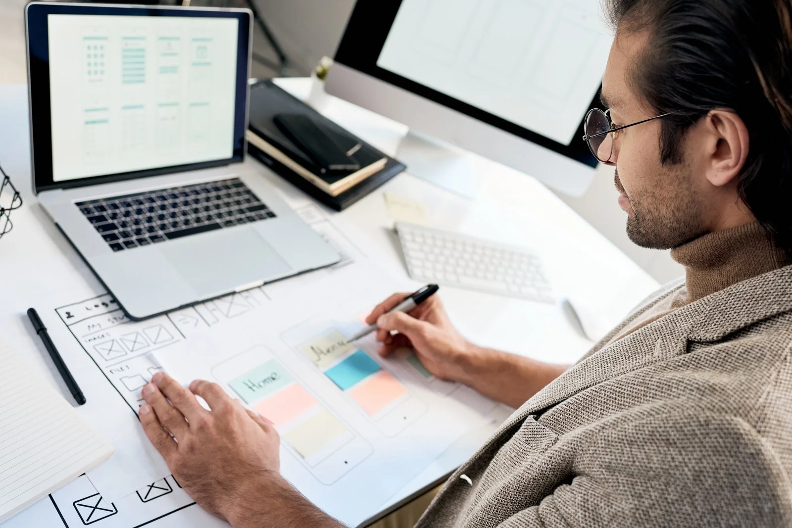 Webdesigner skizziert Layouts am Arbeitsplatz