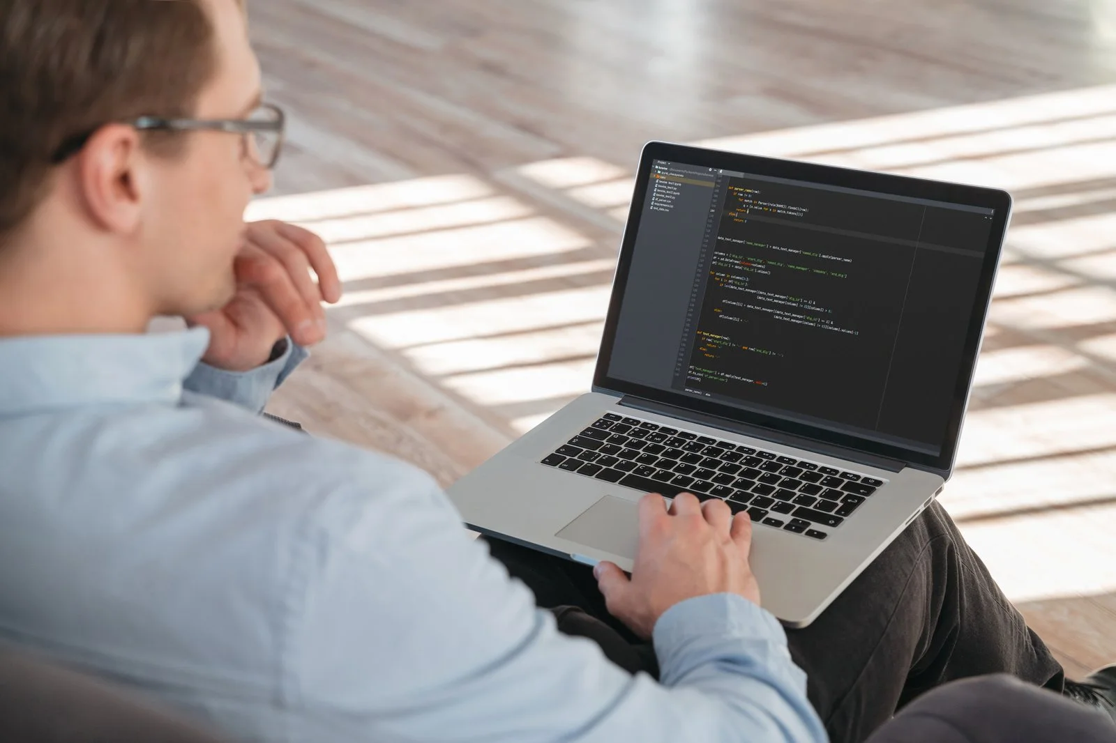Entwickler arbeitet am Laptop an Code